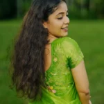 Model wearing parrotcolor saree in designer boutique calicut