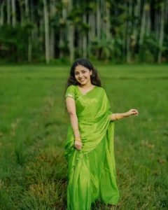 Model wearing parrot green color saree in designer boutique calicut